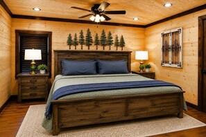 Ein Schlafzimmer mit Holzwänden, einem Bett, einem Deckenventilator und einer Wandleuchte.