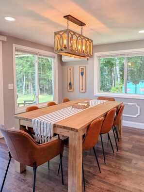 A dining room with a wooden table, six chairs, and a hanging light fixture. - Lakefront - Kids' Hangout - Fire Pit - Kayaks (Barnstead)