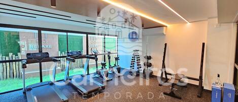 Une salle de sport équipée de tapis de course, de vélos elliptiques et de matériel de musculation.