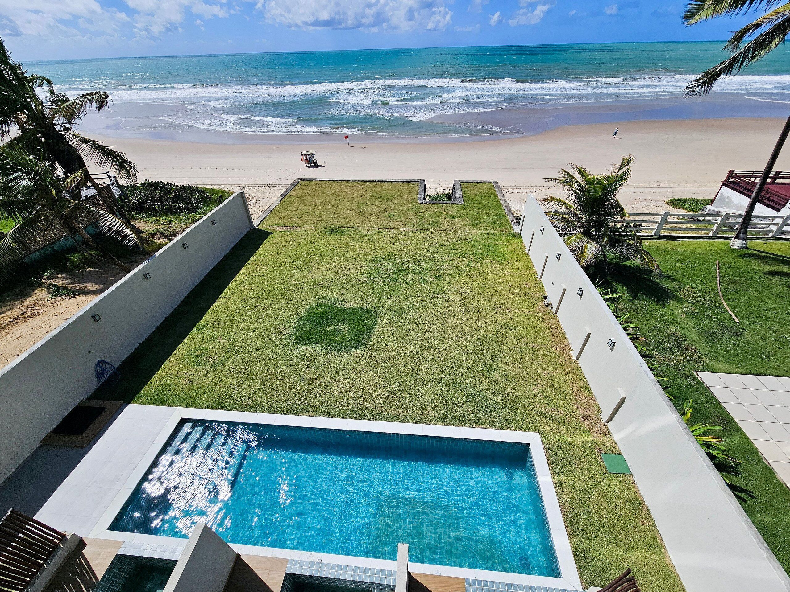 A swimming pool with a view of the beach and ocean.