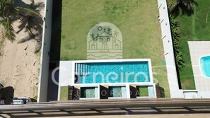 A building with a large sign, a pool, and palm trees. - Waimea Beach Beira-mar em Porto de Galinhas (Ipojuca)