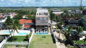 A multi-story building with a pool, surrounded by palm trees and other residential buildings. - Waimea Beach Beira-mar em Porto de Galinhas (Ipojuca)