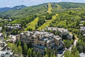 Een resort met meerdere gebouwen, een skilift en een bergachtig landschap.