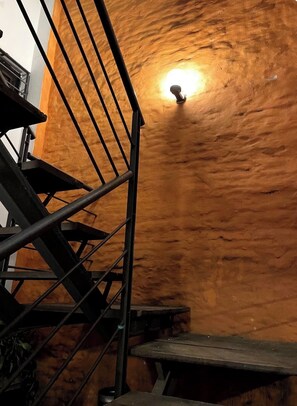 Un escalier avec une rampe métallique menant à un niveau inférieur.