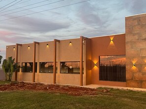 A modern building with a flat roof, large windows, and exterior lighting. - Libre Hotel (Nova Ponte)