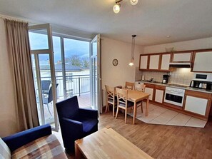A modern apartment with a balcony, a dining area, and a kitchenette. - House by the spa Park (Heringsdorf)