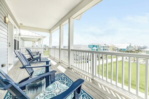 En inglasad veranda med utomhusmöbler och utsikt över ett bostadsområde.