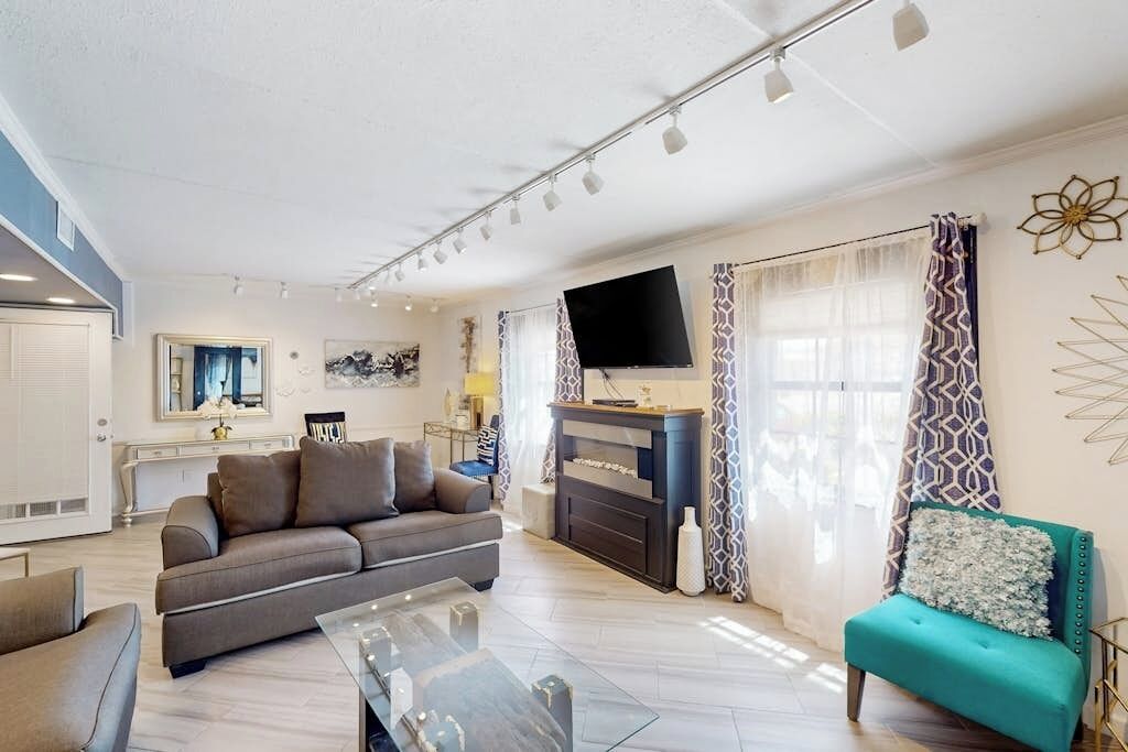 A modern living room with a sofa, a coffee table, and a television.