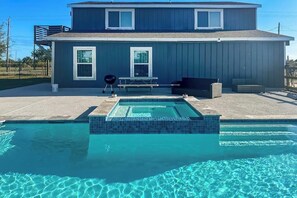 A residential property with a swimming pool, a covered patio, and a two-story house. - Redicare Resort - Upstairs (Galveston)