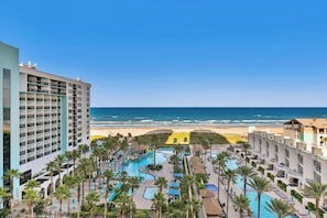 A resort with multiple swimming pools, a beach view, and a large building with balconies. - Sapphire Condominiums #806 (South Padre Island)