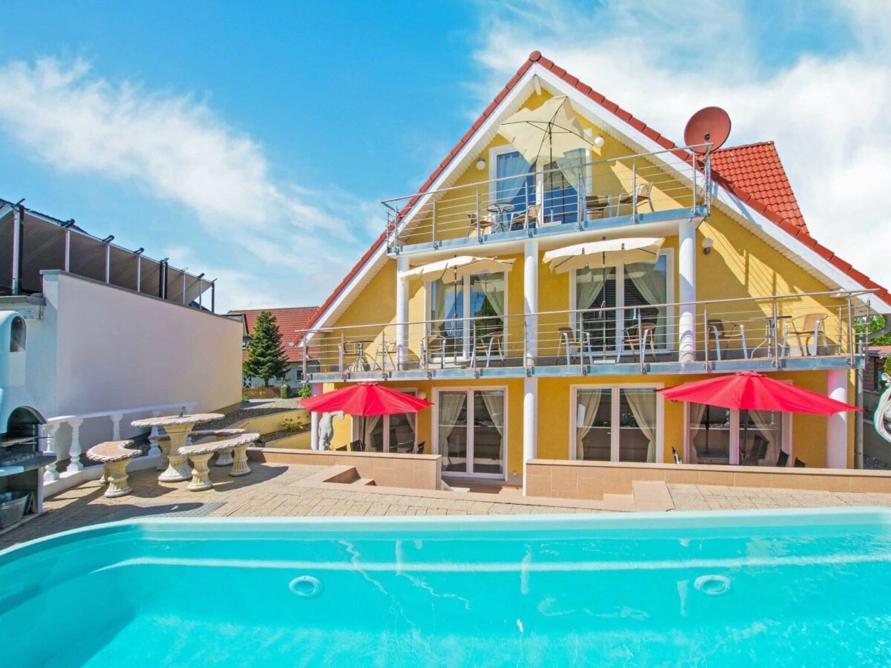 A two-story hotel with a swimming pool, outdoor seating, and satellite dishes.