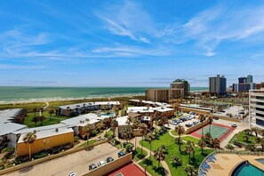 A coastal hotel with multiple buildings, a parking lot, and a tennis court. - Sunchase IV #715 - Gulf Views, Pools & Hot Tub (South Padre Island)
