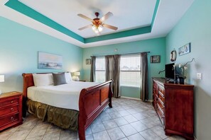 A bedroom with a bed, a dresser, a ceiling fan, and a window with curtains. - Serene Sanctuary at 20 Torrey Pines (Laguna Vista)