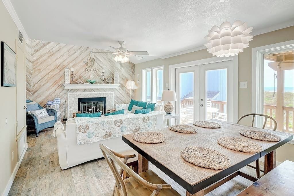 A dining area with a wooden table, woven placemats, and a ceiling fan.