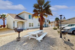 A residential property with a white house, a picnic table, a grill, and a palm tree. - The Blue House by Whitecap Beach (Corpus Christi)