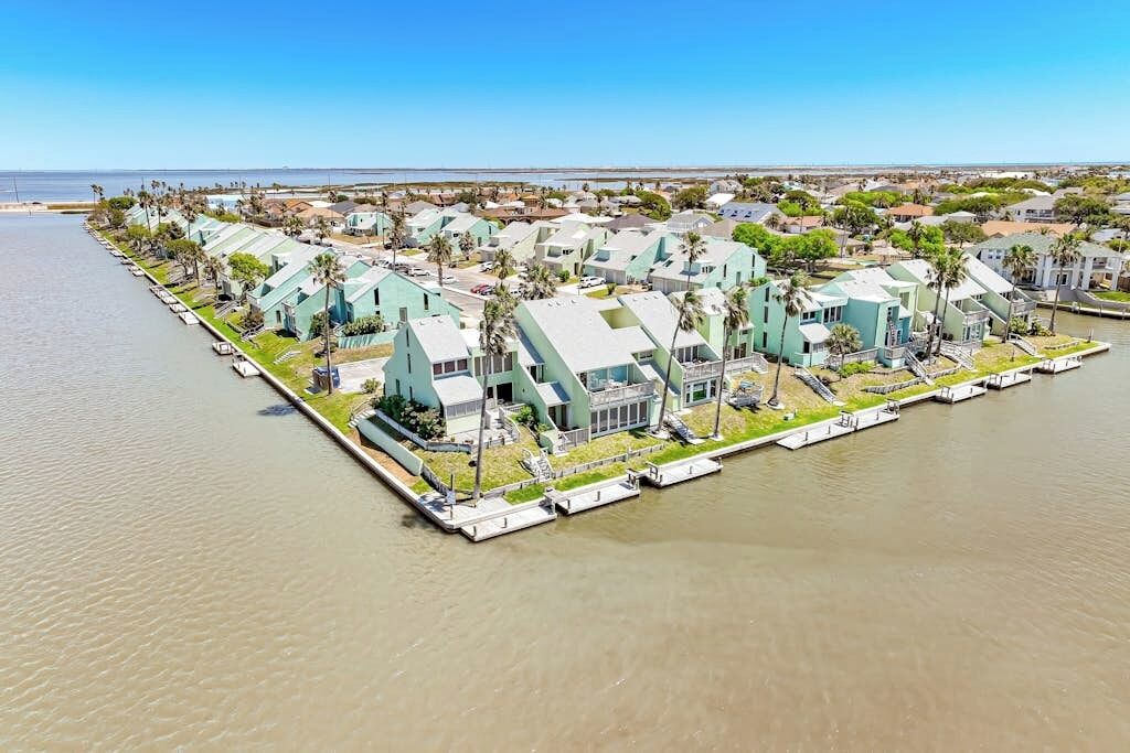 A waterfront property with multiple buildings, docks, and a clear view of the water.