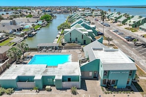 Ein Hotel an der Küste mit Schwimmbad, mehreren Gästezimmern und einem Yachthafen.