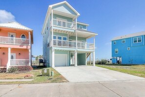 Um edifício residencial de vários andares com varanda frontal coberta e garagem.