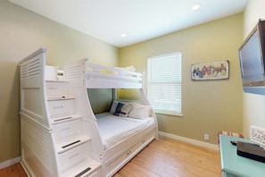 A bunk bed room with a window, a wall-mounted TV, and a framed picture. - Ocean Village 18 Sea Ya Soon (Port Aransas)