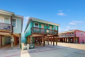 A building with a balcony, a covered area, and a clear sky. - Ocean Village 18 Sea Ya Soon (Port Aransas)