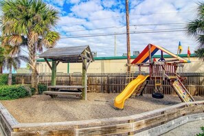 A playground with a slide, climbing structure, and a wooden bench. - Nemo Cay 15106 - Pool, Patio, Sleeps 10, Dogs OK (Corpus Christi)