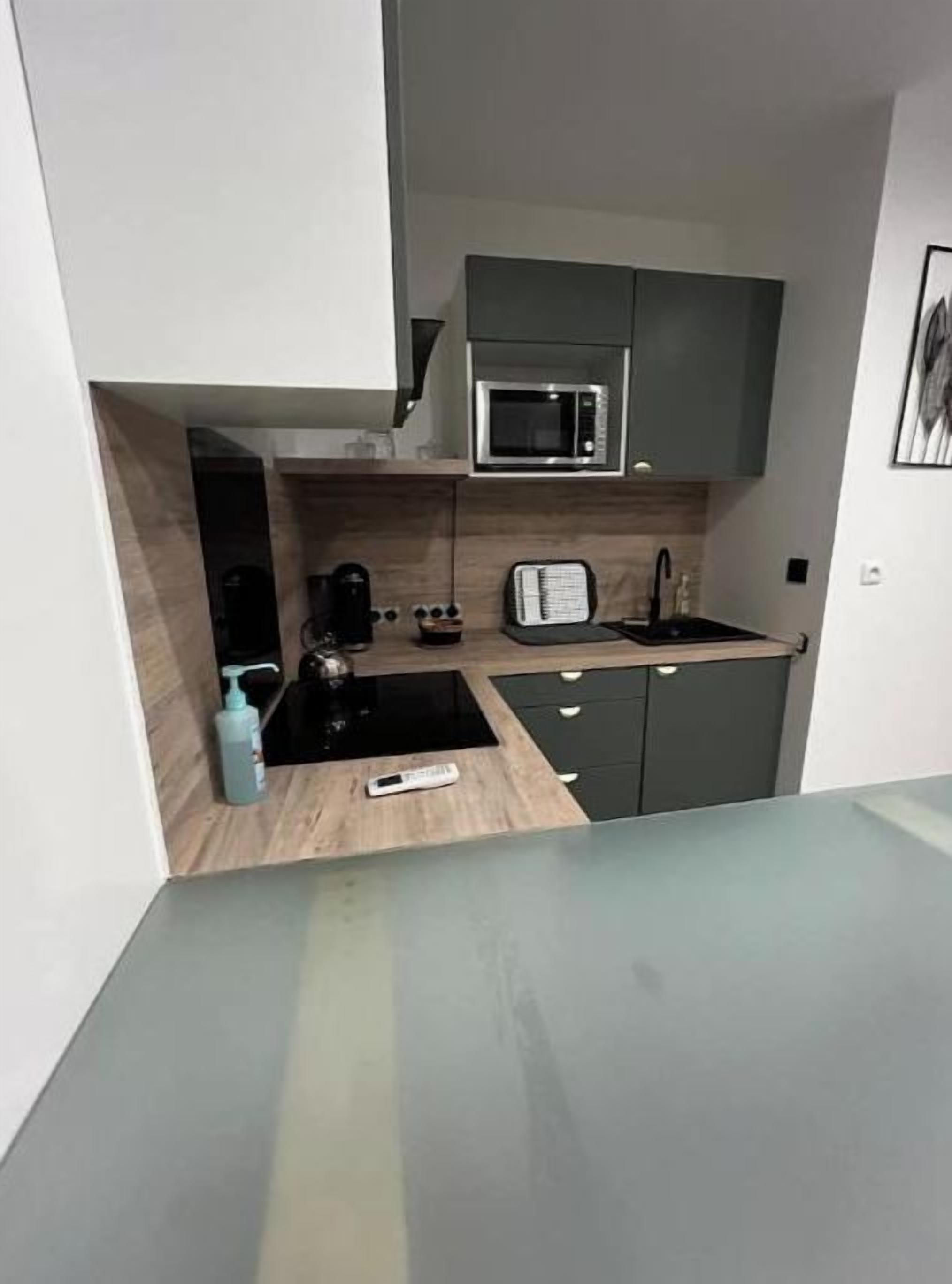 Een kleine keuken met een magnetron, broodrooster en koffiezetapparaat.
