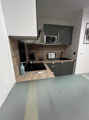 Een kleine keuken met een magnetron, broodrooster en koffiezetapparaat.