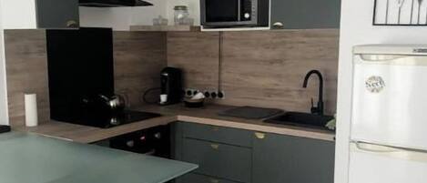 A modern kitchen with a microwave, stove, and refrigerator.