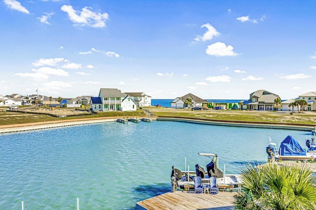 A waterfront property with a dock, boats, and houses.