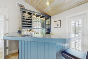 Une cuisine dotée d’un bar bleu, de meubles-bar intégrés et d’un tableau encadré au mur.