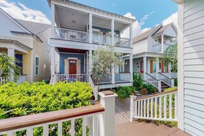 A two-story residential building with a balcony, a front porch, and a wooden deck. - Bay Dream Believer - Ocean Views & Shared Pool (Rockport)