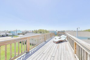 A wooden deck with lounge chairs and a view of houses in the background. - Another Tequila Sunrise (Rockport)