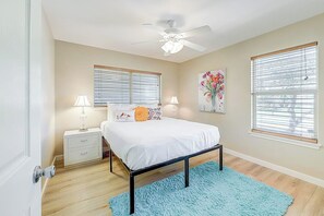 A bedroom with a bed, bedside tables, a ceiling fan, and windows with blinds. - Another Tequila Sunrise (Rockport)