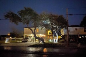 Un edificio de dos pisos con una entrada visible y un área techada, posiblemente un vestíbulo o recibidor.