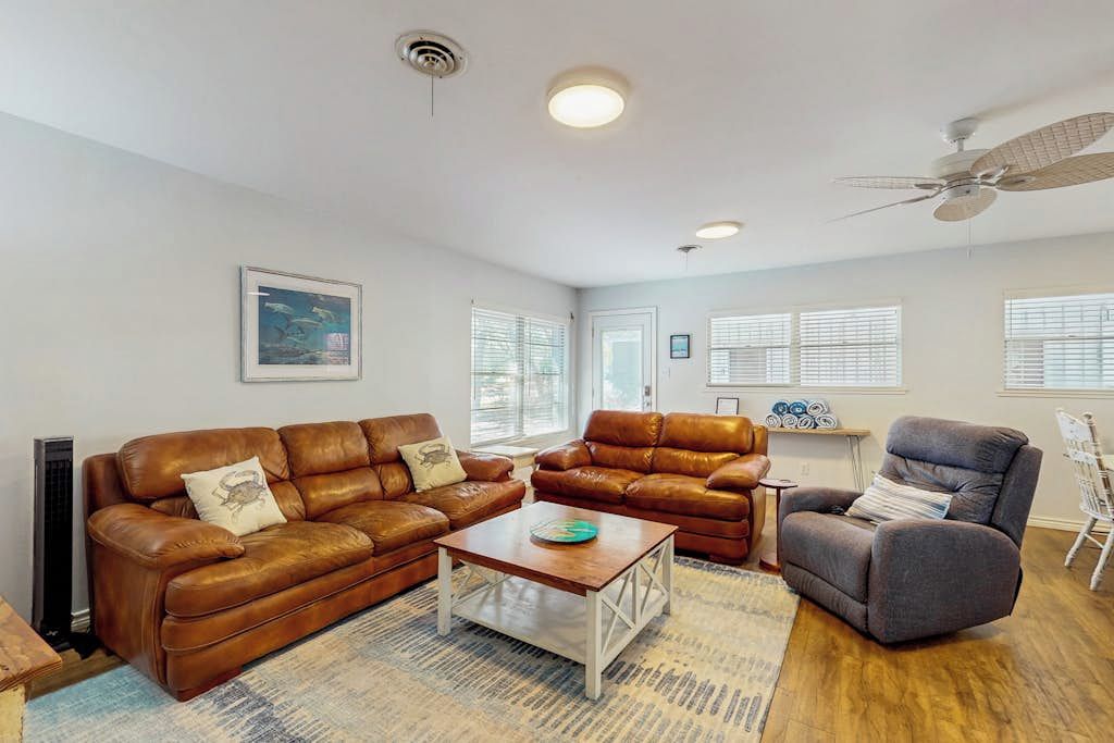 A living room with a brown leather sofa, a gray recliner, and a coffee table.