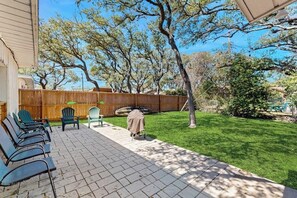 Eine Terrasse mit Sitzgelegenheit und Holzlattenzaun.