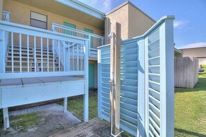 A residential building with a white exterior, a wooden deck, and a gated entrance. - Nelray Shores at Seamist Condominiums (Port Aransas)