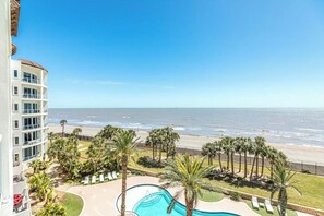Ein Hotel mit Pool, Palmen und Blick auf den Strand.