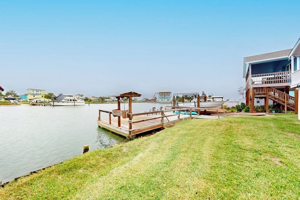 Une propriété située au bord de l’eau, dotée d’un quai, d’une piscine et d’une maison avec balcon.