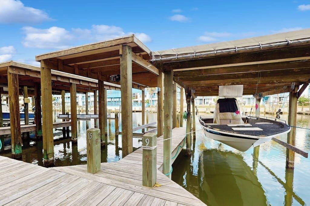 Un muelle de madera con una embarcación amarrada debajo de una zona cubierta.