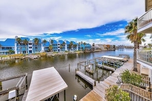 A waterfront hotel with multiple blue buildings, docks, and a calm water body. - Compass Condominiums B8 (Corpus Christi)