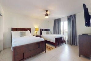Une chambre d’hôtel avec deux lits, une télévision et une fenêtre avec des rideaux.