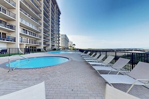 Un espace piscine d’hôtel avec des chaises longues et une piscine.