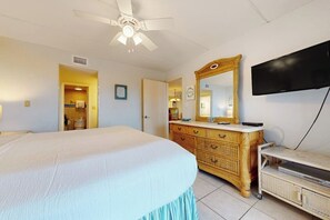 A bedroom with a bed, a dresser, a television, and a ceiling fan. - Saida Towers I #402 - Oceanfront, Pools & Hot Tub (South Padre Island)