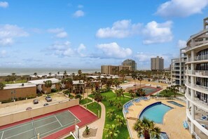 A resort with a pool, tennis courts, and a view of the ocean. - Sunchase IV #509 - Gulf & Bay Views, Pools & Gym (South Padre Island)