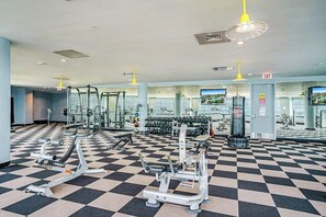 A gym with various exercise equipment, a checkered floor, and multiple mirrors. - Diamond Beach Resort - A Shore Thing (Galveston)