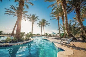 A swimming pool with palm trees and lounge chairs. - Pointe West Resort - Sand Swept (Galveston)