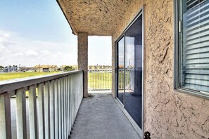 Ein Balkon mit Blick auf eine Grünfläche und Gebäude in der Ferne.