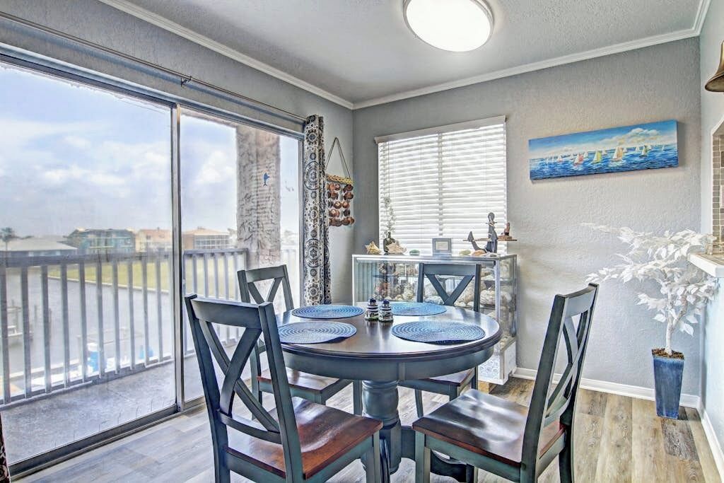 Un coin repas avec une table ronde, des chaises et une vue à travers une porte vitrée.