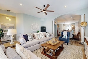 A living room with a sofa, coffee table, and a ceiling fan. - Padre Island 104 - Ocean Views, Walk to the Beach (Corpus Christi)